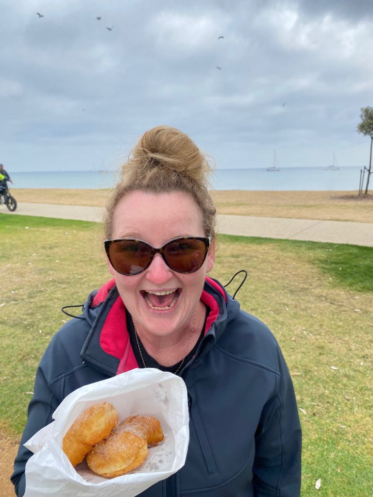 Casey-holding-the-donuts-with-the-Portarlington-beach-in-the-background
